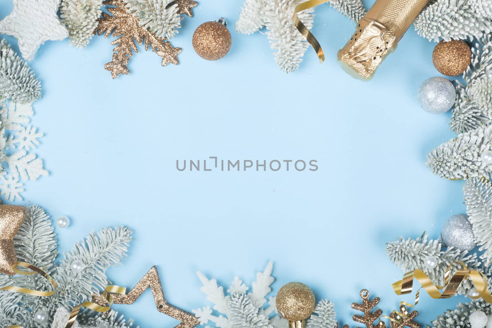 Frosted fir tree twigs and Christmas decorative bauble balls on blue background with copy space for text template flat lay top view design