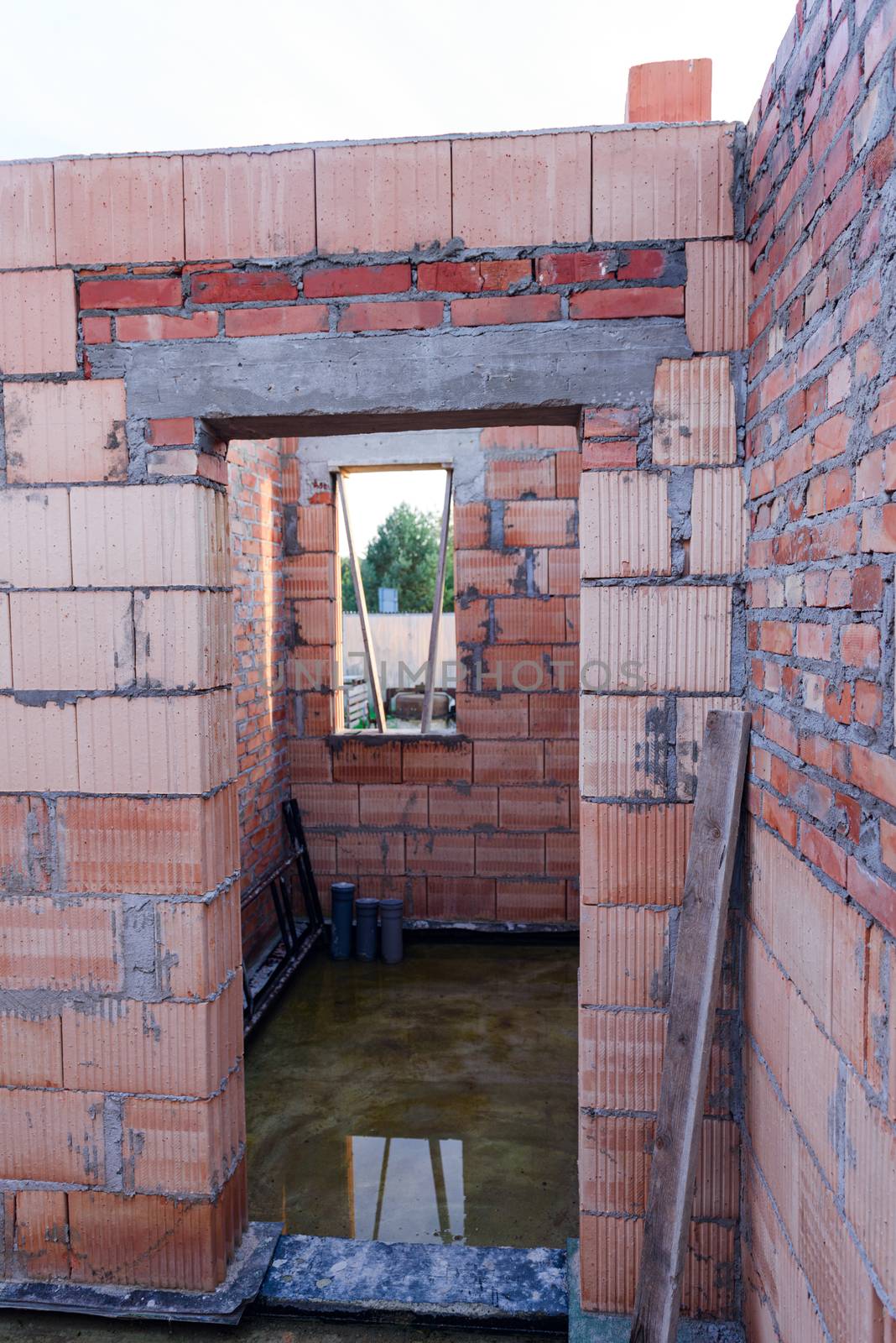 Interior of a Unfinished Red Brick House Walls under Construction without Roofing.