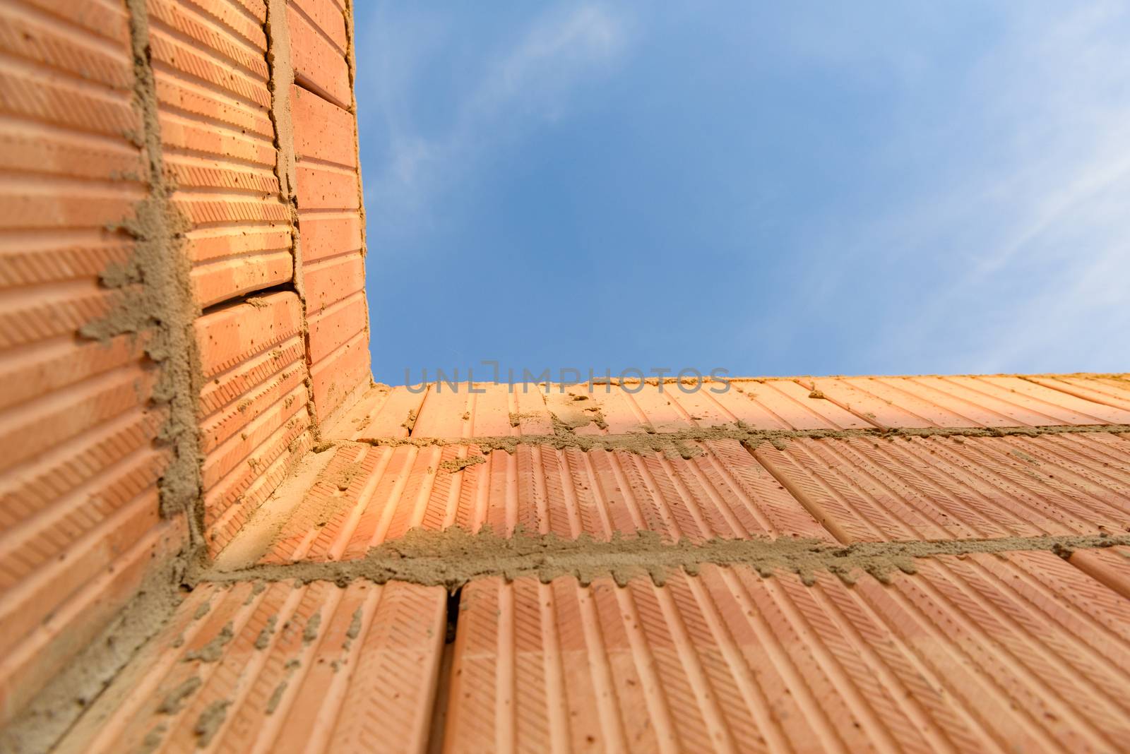 Interior of a Unfinished Red Brick House Walls under Construction without Roofing.