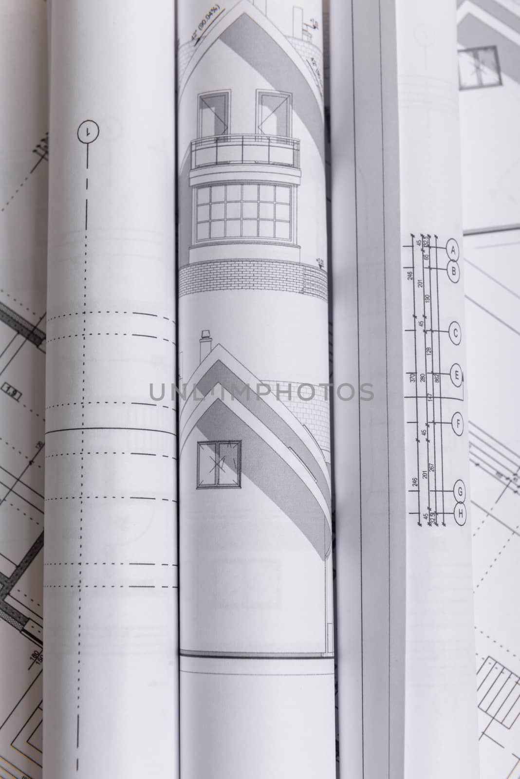 White family paper house, house projects plan and blueprints in the background. Minimalistic and simple concept, style. Horizontal orientation. View from above.
