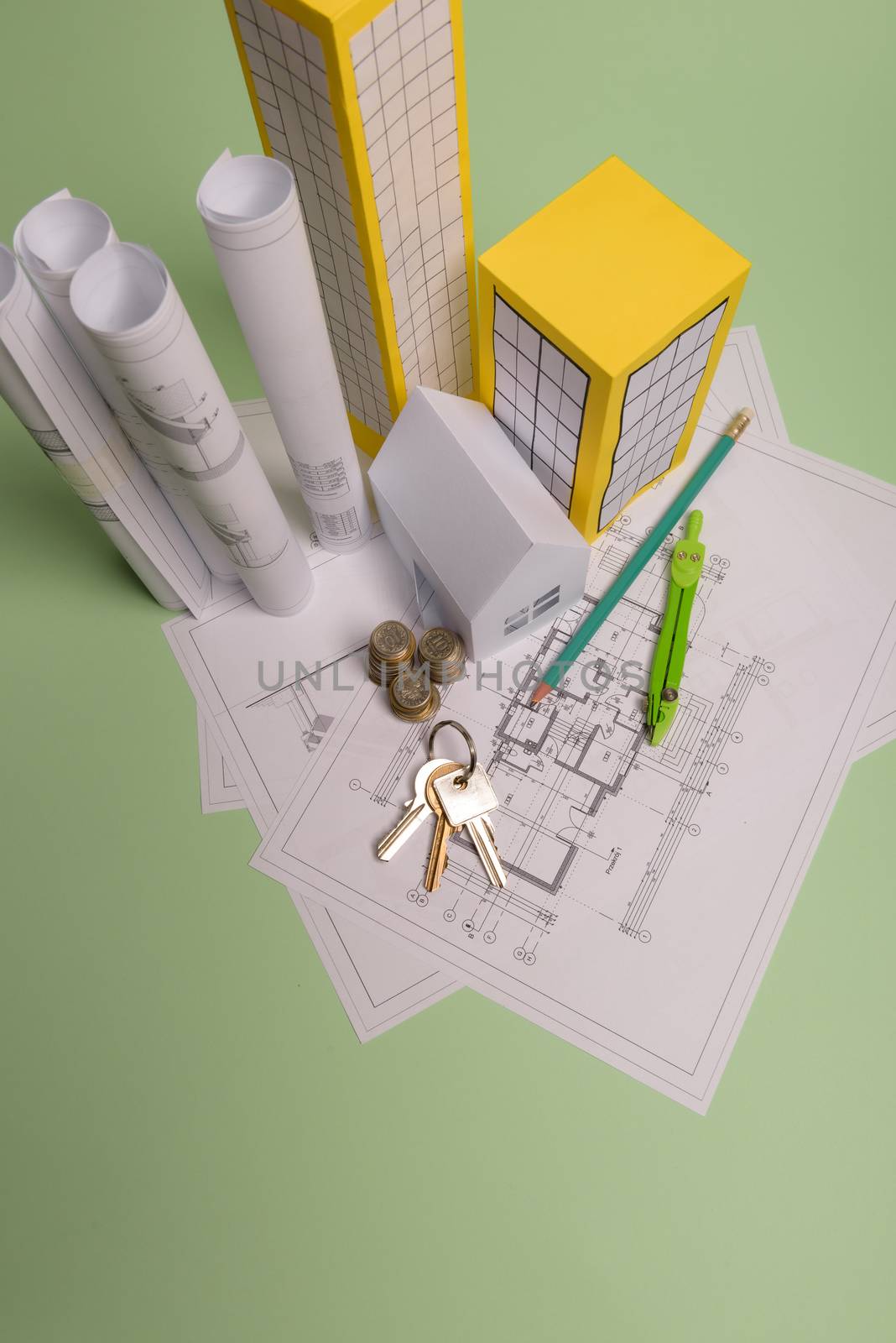 White family paper house, house projects plan and blueprints in the background. Minimalistic and simple concept, style. Horizontal orientation. View from above.