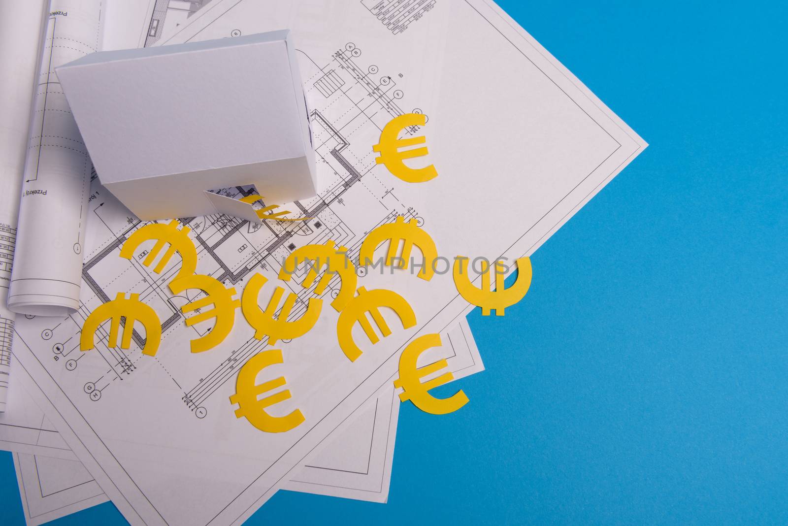 Paper skyscrapers , euro money, house projects plan and blueprints on blue background paper. Minimalistic and simple concept, style. Horizontal orientation. View from above.