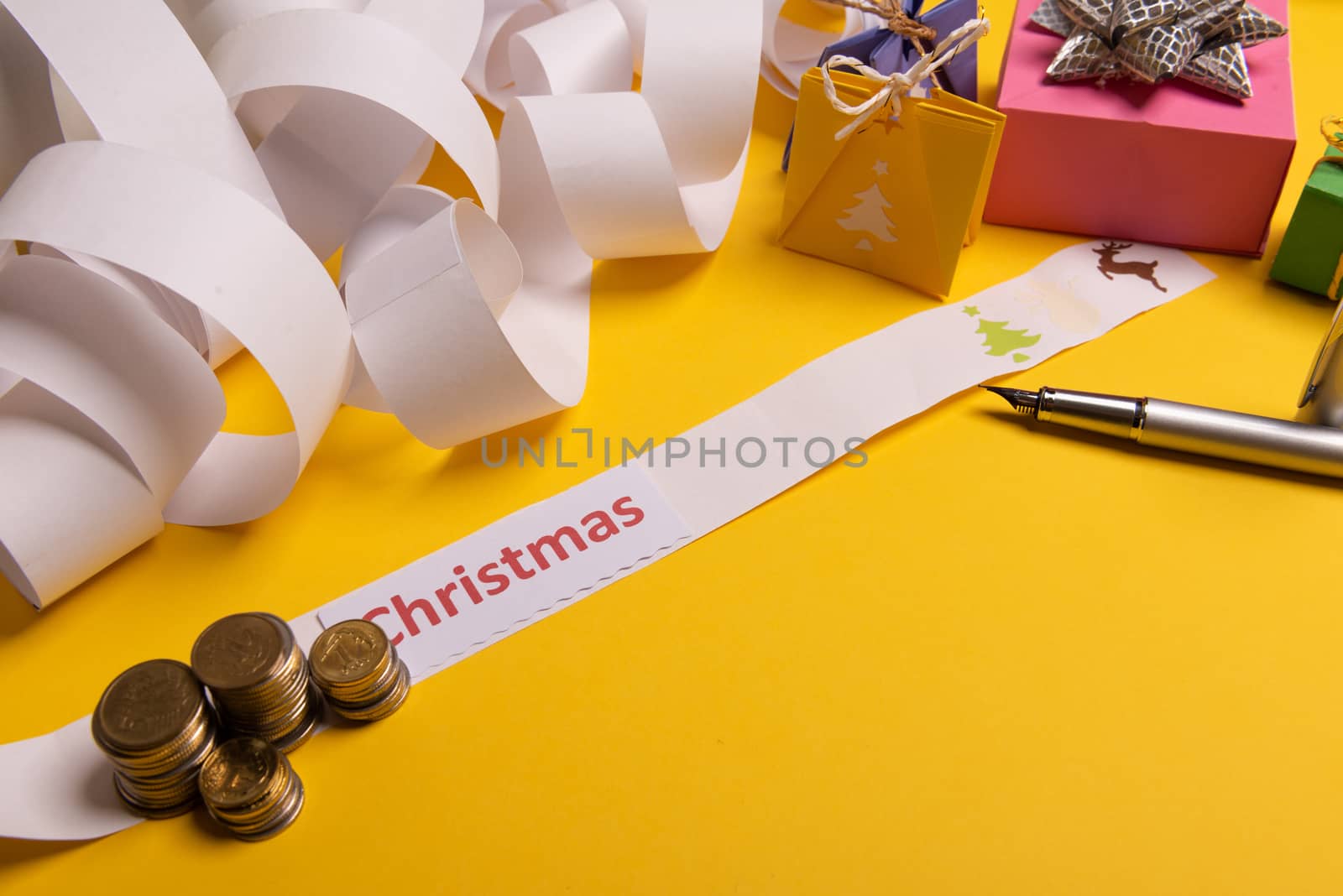 Holiday expenses concept. Long twisted christmas expenses list, presents, gifts, money coins and christmas text