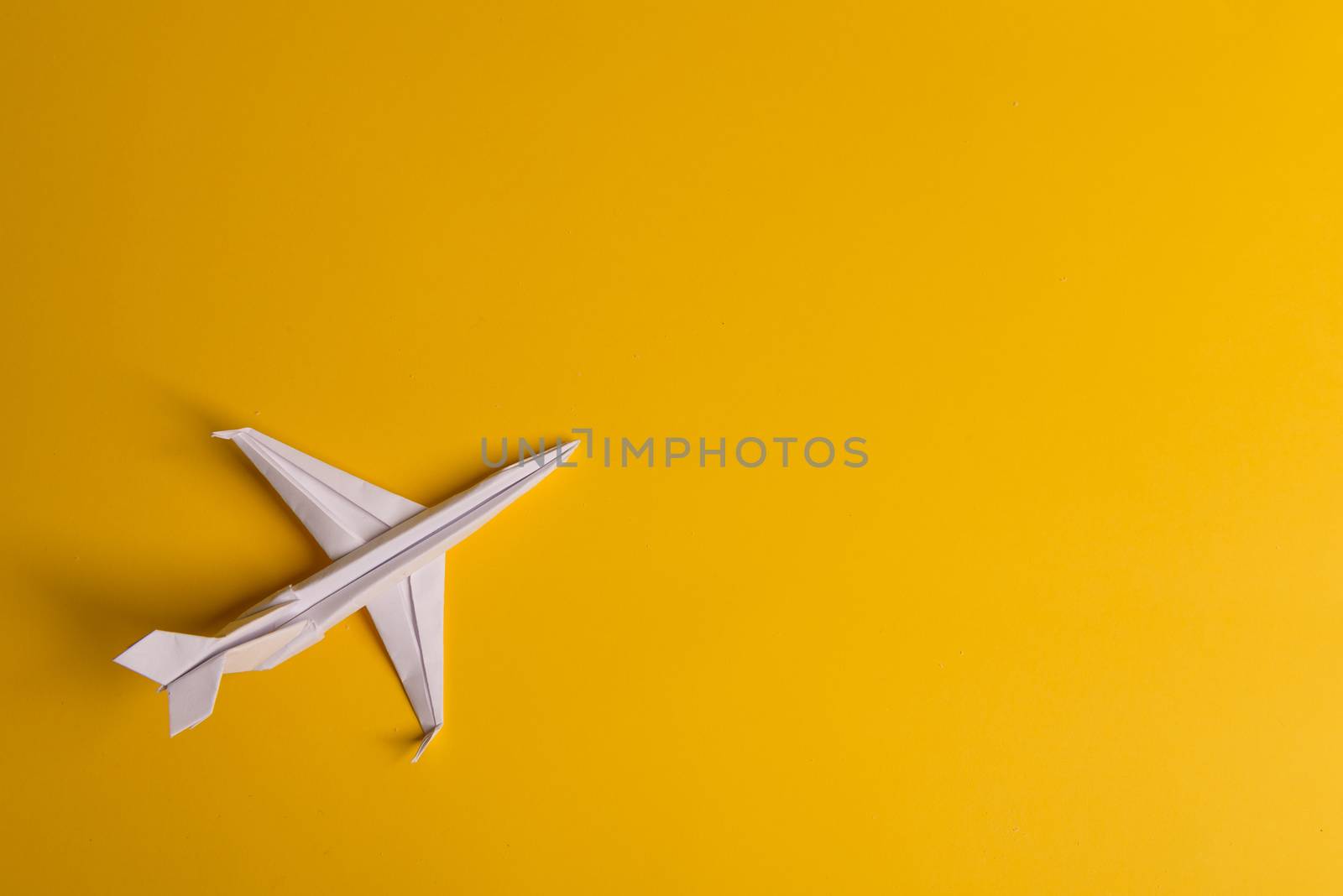 Group of paper plane in one direction and with one individual pointing in the different way on yellow background. Business for innovative solution concept. Dotted line from aircraft tail.