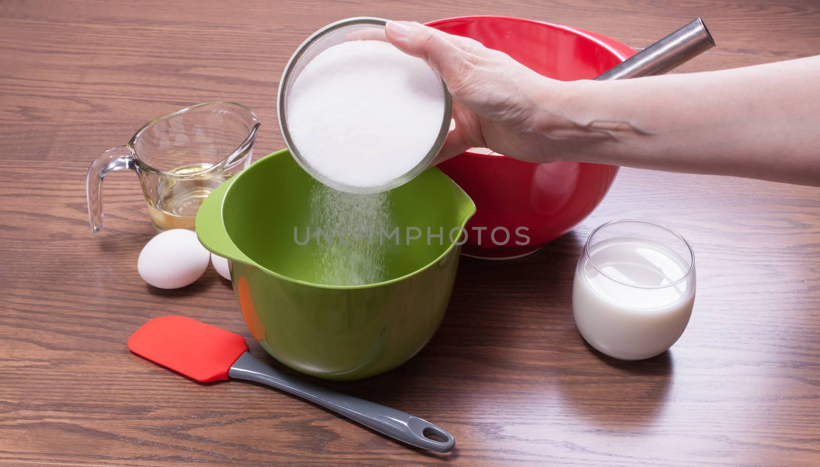 Pouring sugar in a bowl to cook a homemade cake from scratch