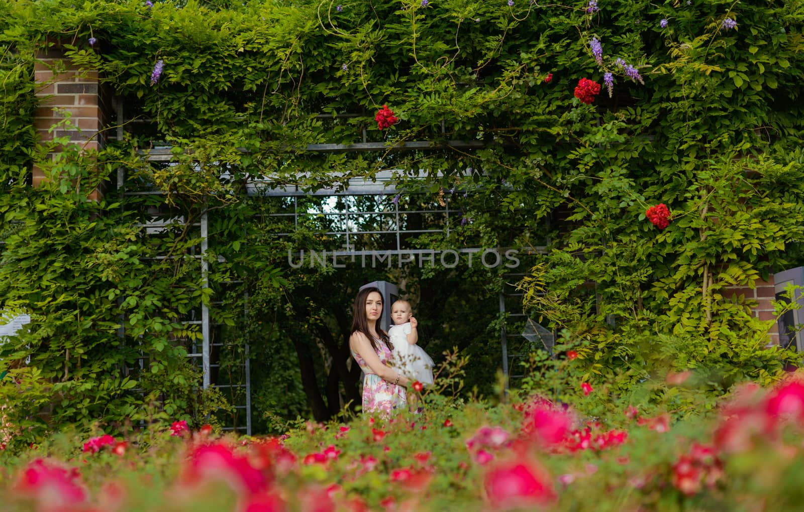 Happy mother and daughter in the park. Beauty nature scene with family outdoor lifestyle. Happy family resting together on the green grass, having fun outdoor. Happiness and harmony in family life.