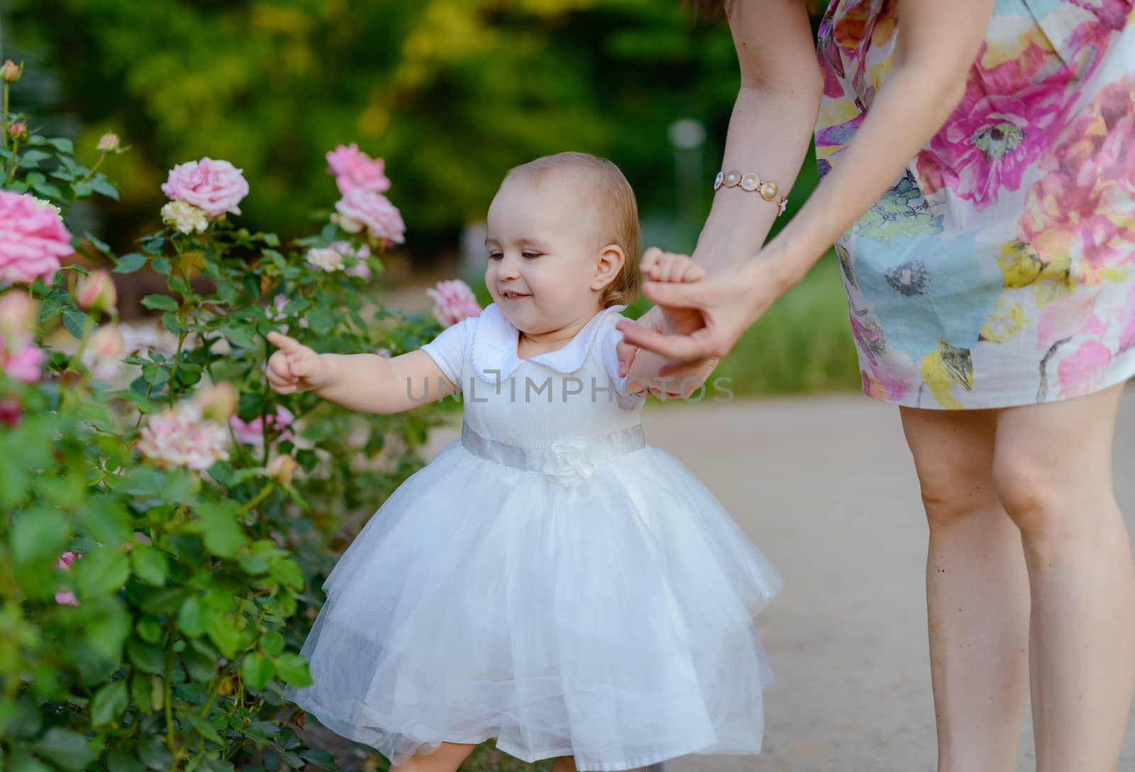 Happy mother and daughter in the park. Beauty nature scene with family outdoor lifestyle. Happy family resting together on the green grass, having fun outdoor. Happiness and harmony in family life.