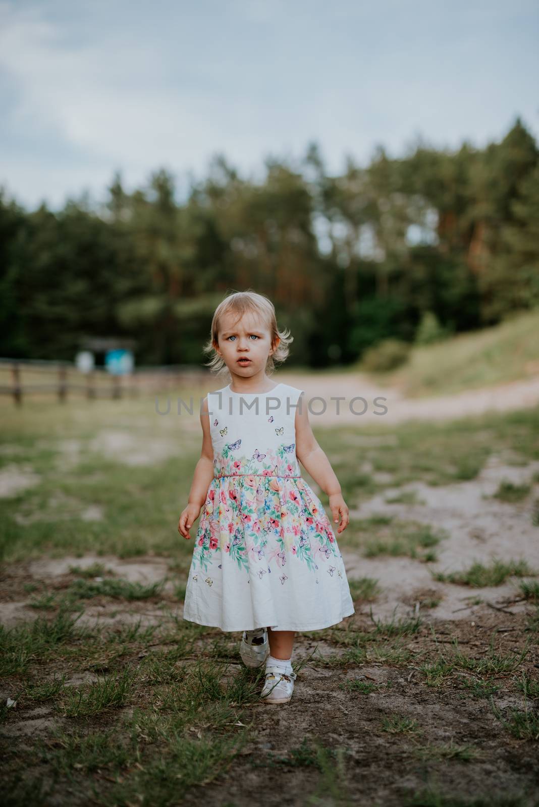 Smiling girl in the park in summer time. Authentic lifestyle image