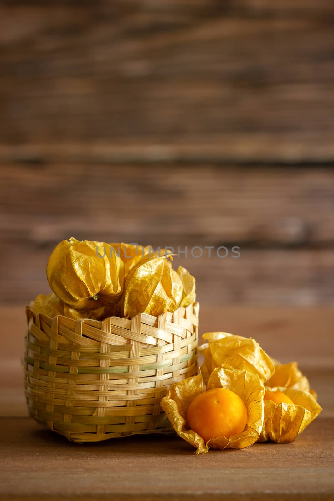 Cape gooseberry in bamboo basket. Concept of health care or herb. Closeup and copy space for text.