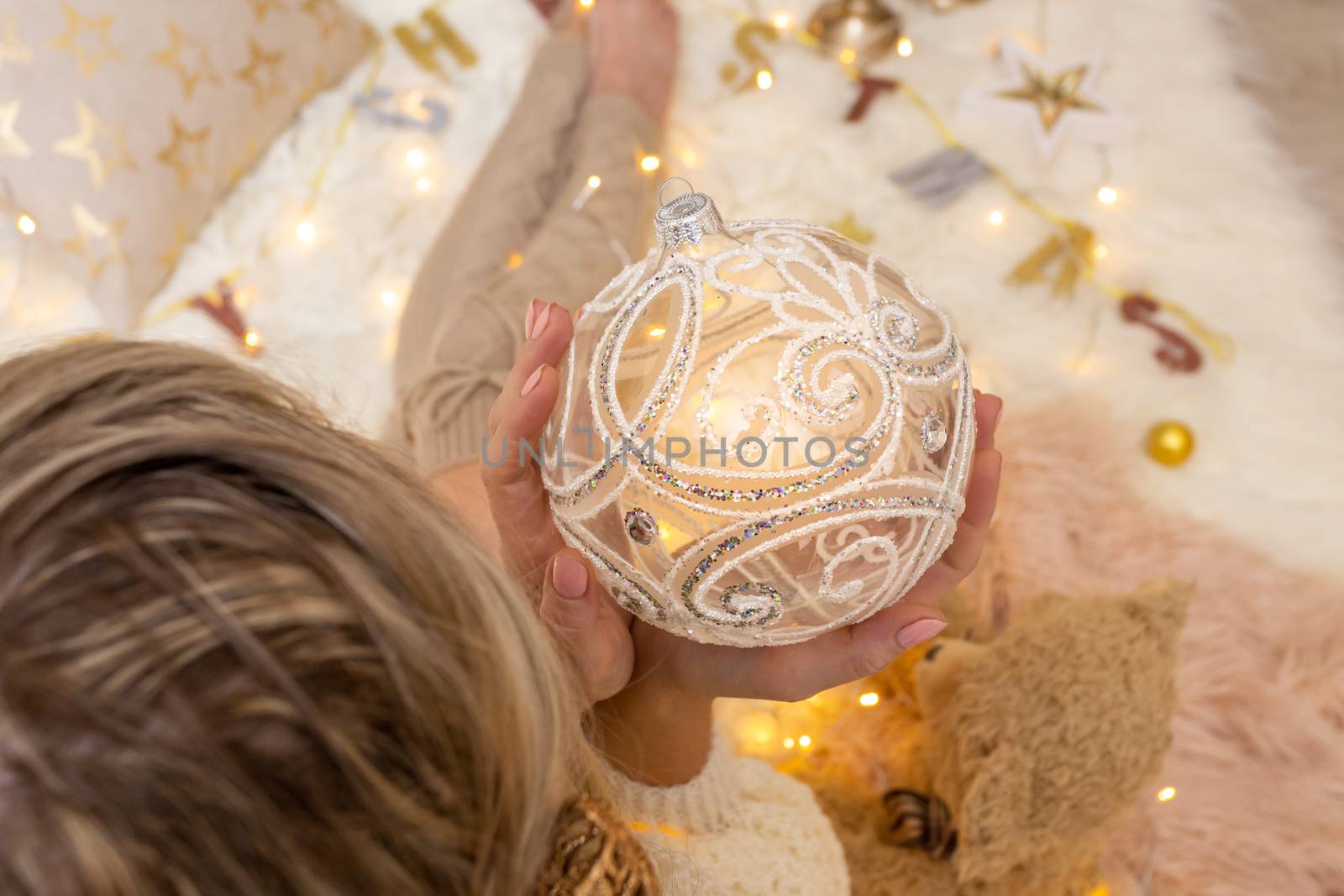 Woman holds ornate decorative swirly glitter design Christmas bauble decoration