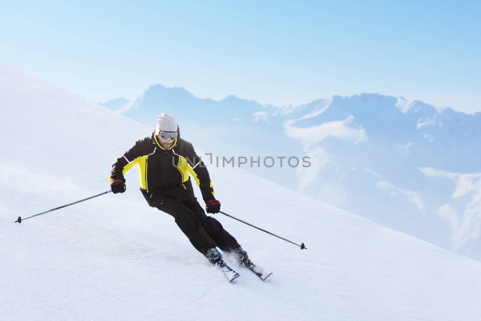 Alpine skier on piste running downhill by destillat