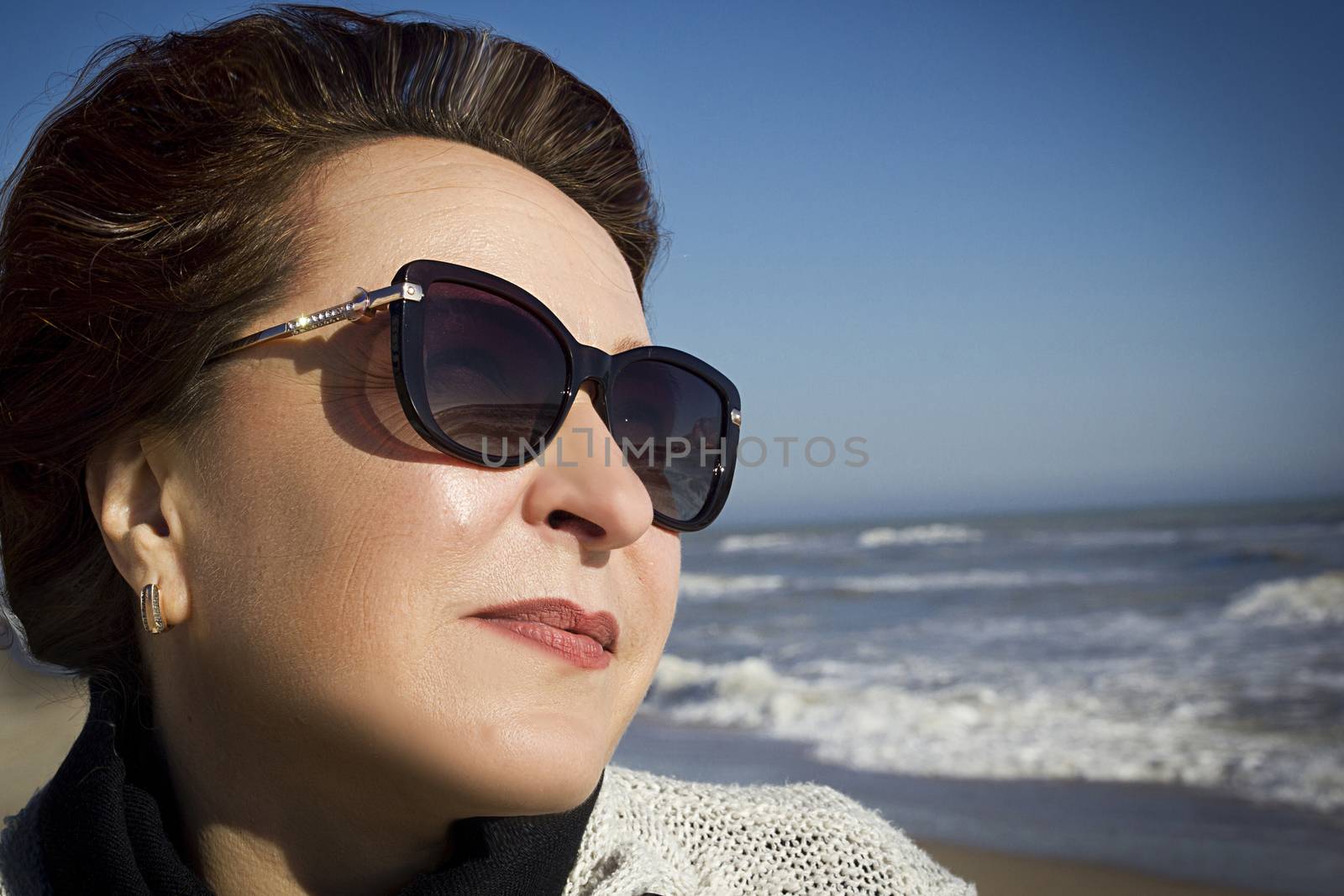 Portrait of a woman in sunglasses on a sea sandy beach