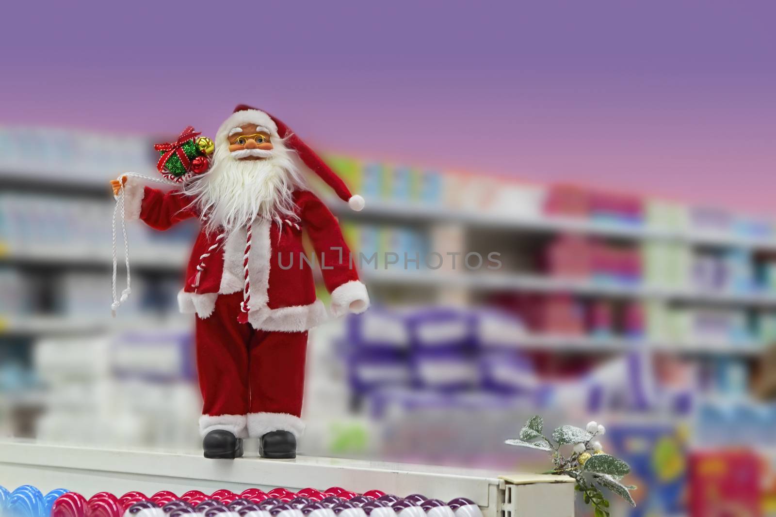 Festive Christmas decoration of the store. Toy Santa Claus decorates the interior of the supermarket. New Year's mood.