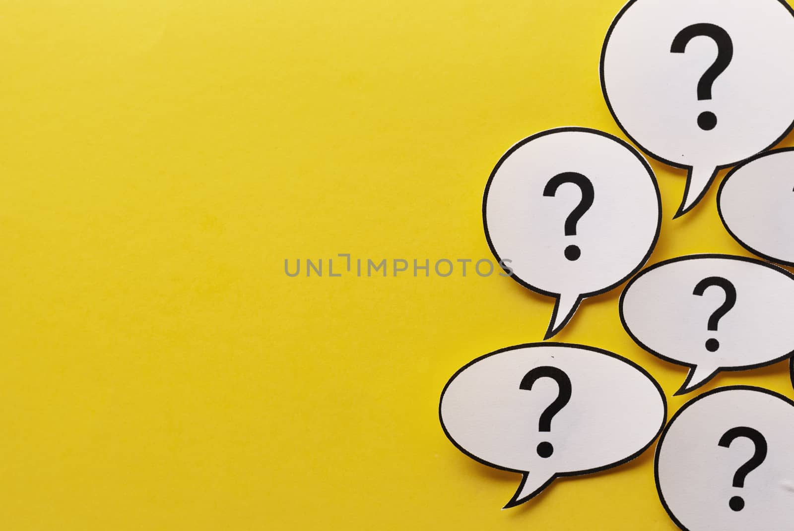 Border of question marks in speech or thought bubbles over a vivid yellow background with copy space