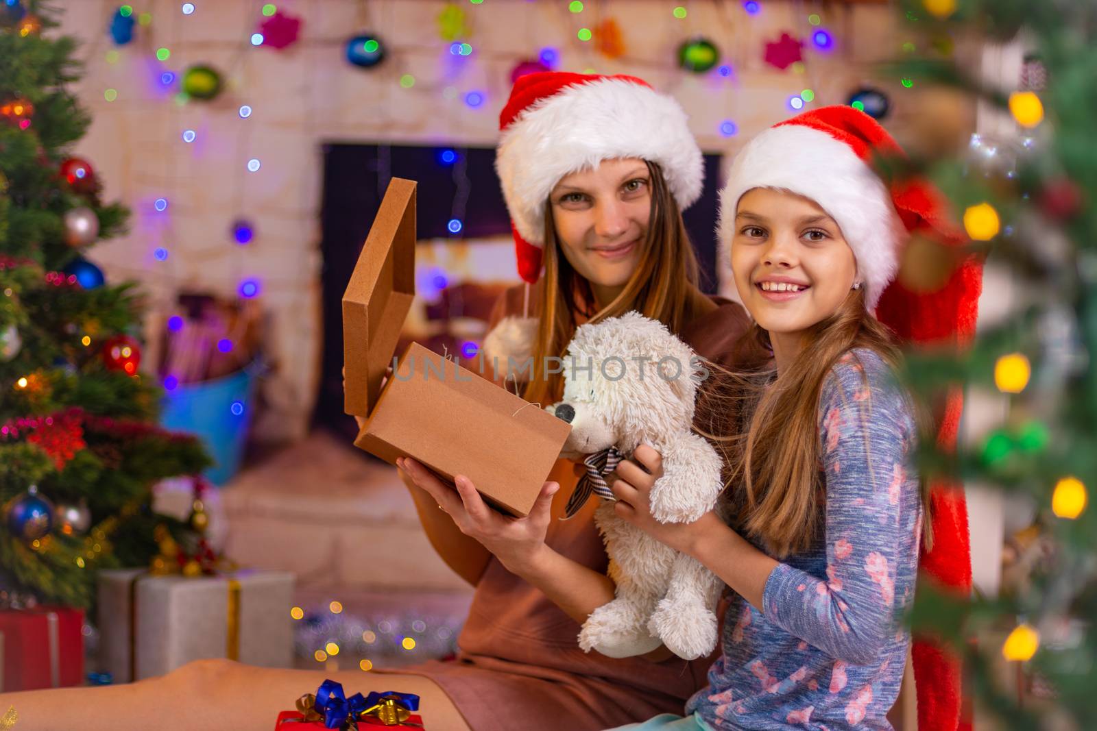 Mom and daughter opened the Christmas box with a gift and looked into the frame