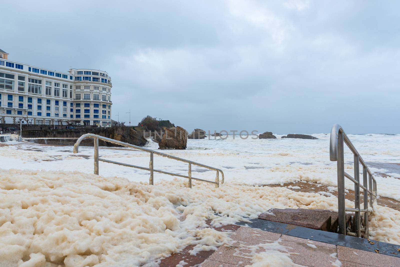 Foam on the Grande Plage beach and its quay during a storm, France