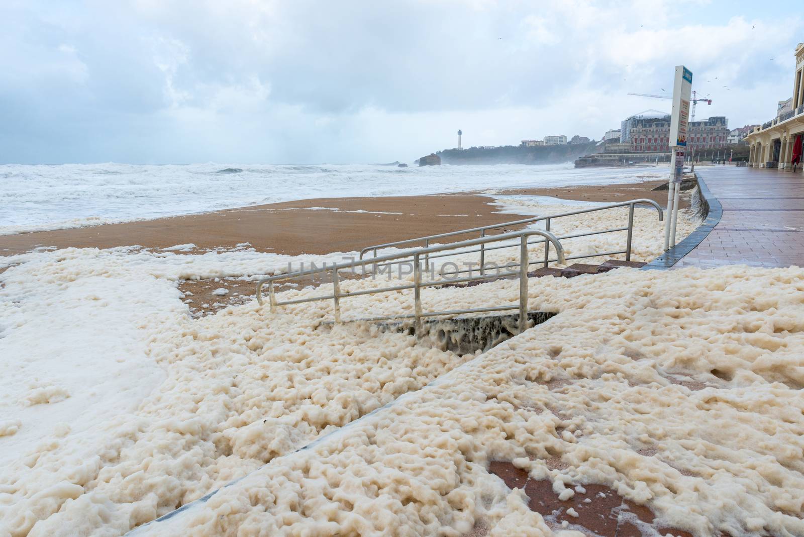 Foam on the Grande Plage beach and its quay, France by dutourdumonde