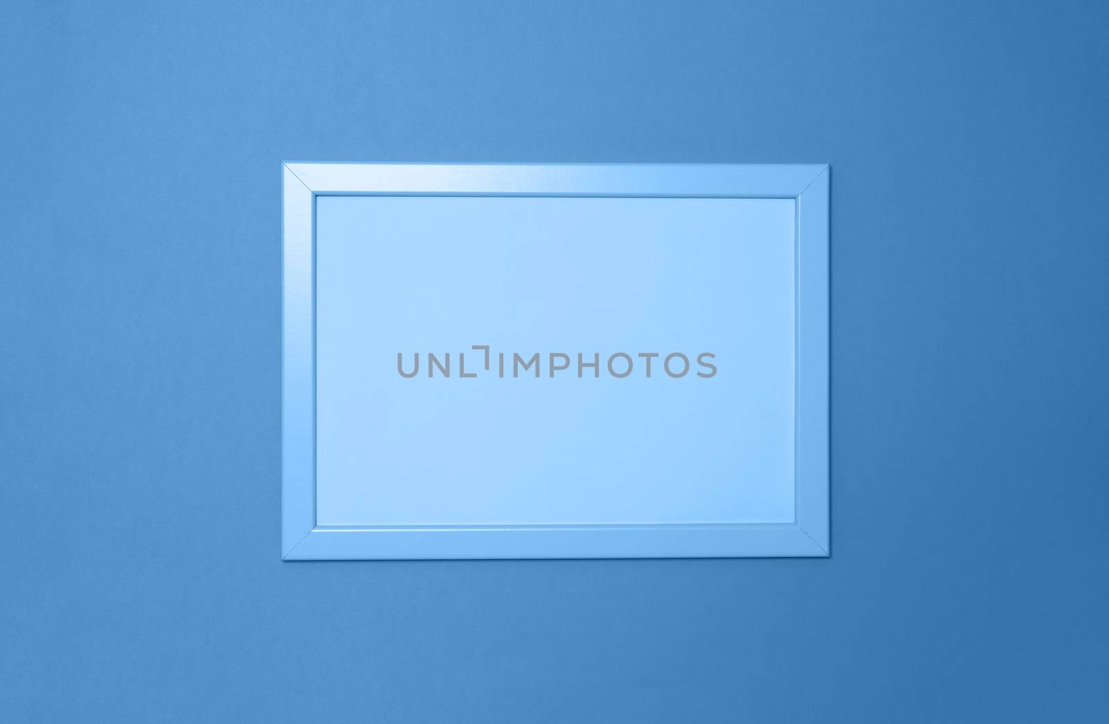 Empty photoframe on background in Classic Blue colour. Copy space for text. Horizontal. Color of the year 2020 concept, harvesting for mock up. Top view. Minimal style concept.