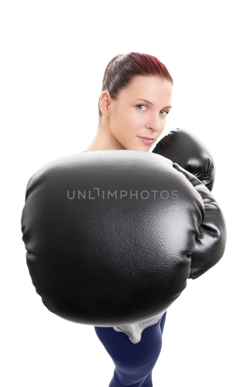 Close up shot of a young beautiful woman with boxing gloves punching or jabbing towards the camera, isolated on white background. Focus on the black boxing glove. Sport concept.