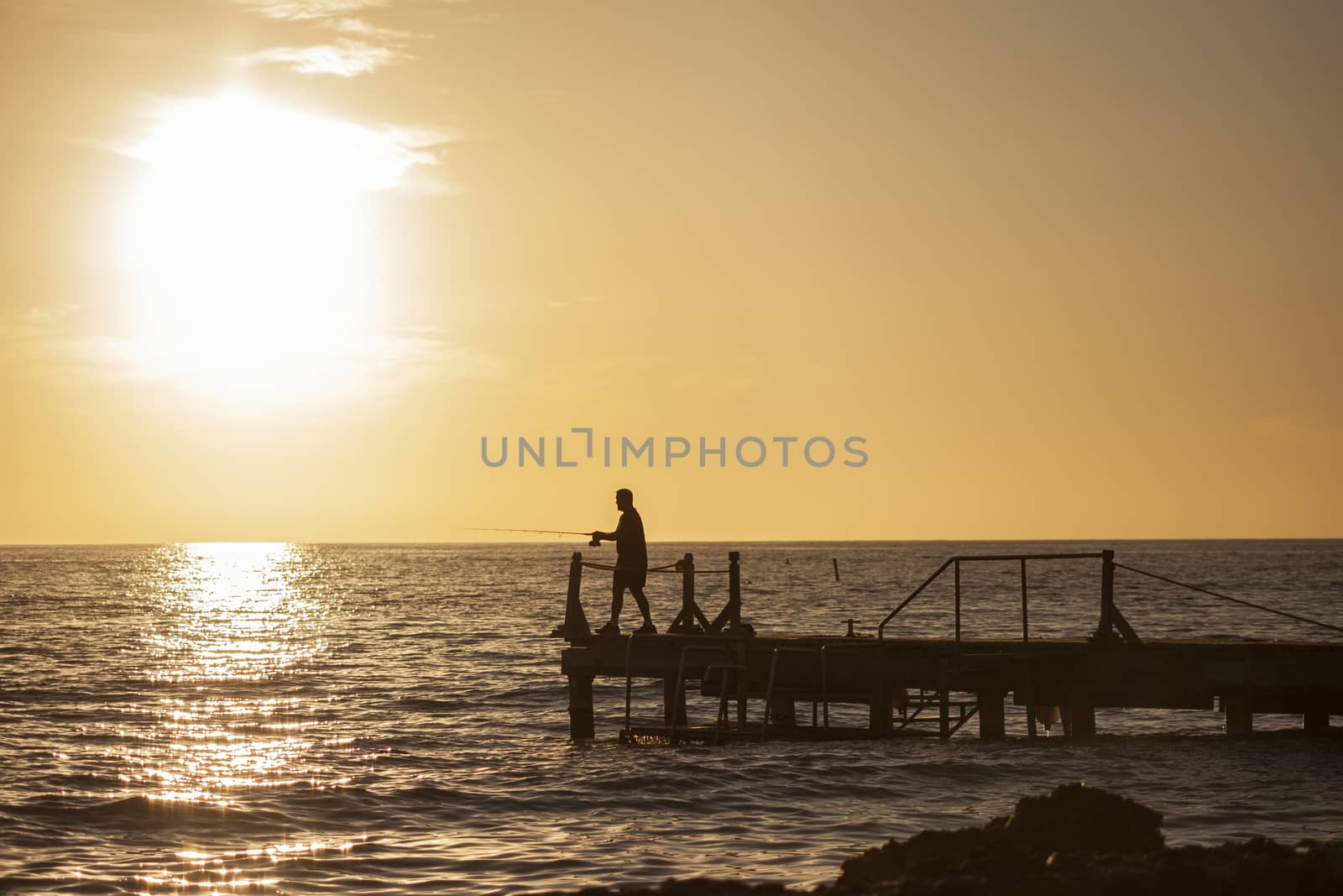 Fisherman on the pier at sunset in Bayahibe 7 by pippocarlot