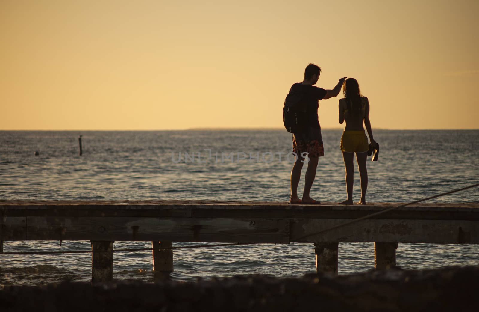 Silhouette Loving couple by the sea at sunset by pippocarlot