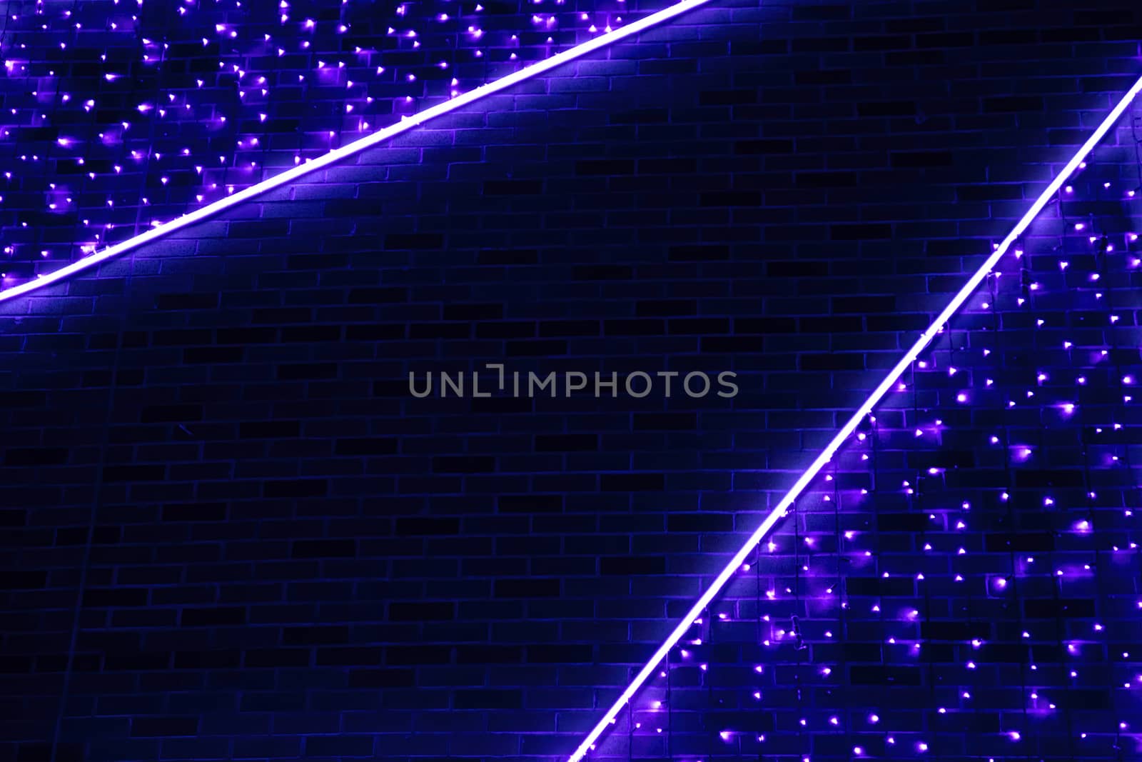 Neon blue light against the background of a brick wall. Abstract background of deep blue color.