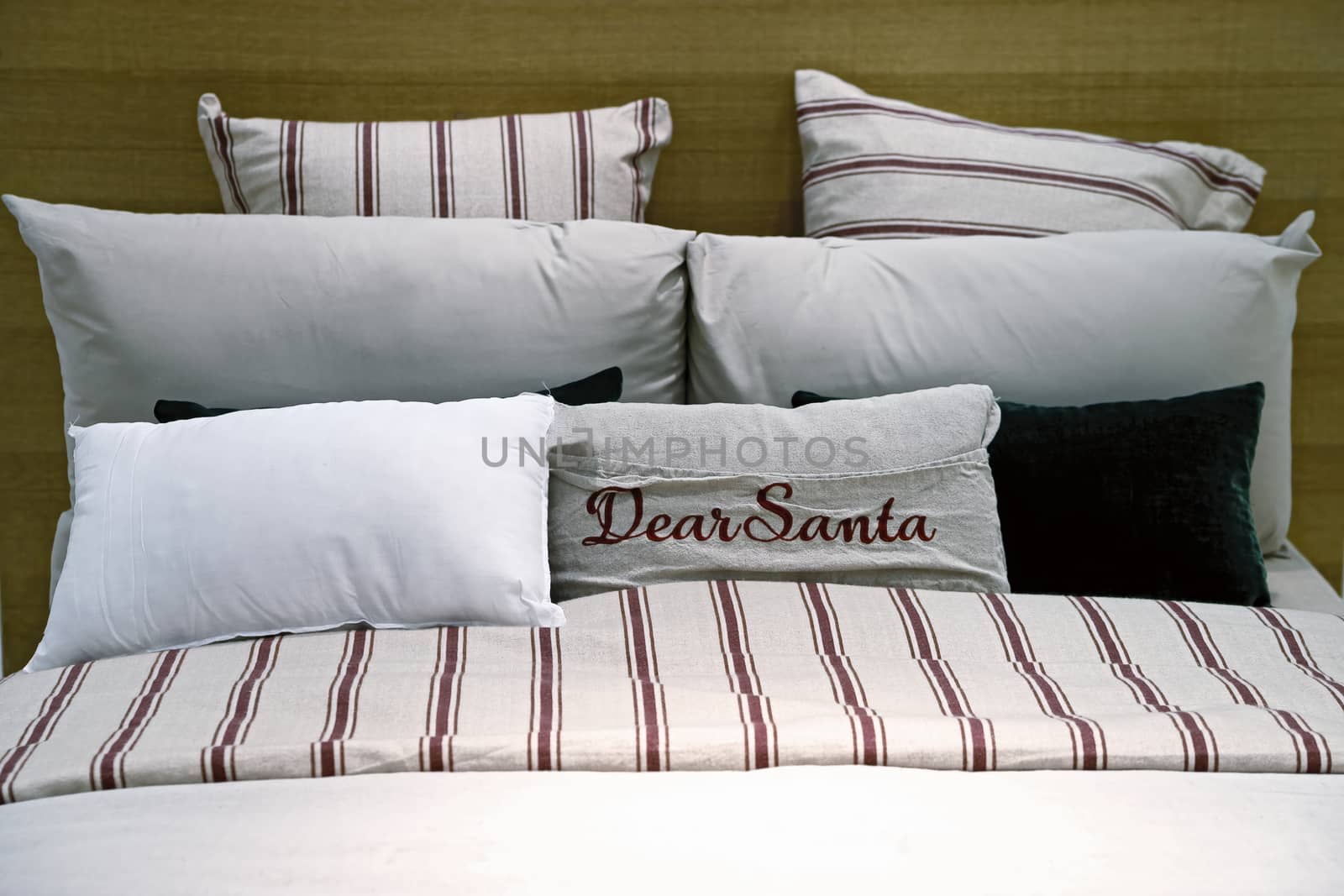 A cozy bed with soft pillows for rest during the Christmas holidays. Bed linen made of natural linen. Blurred background.