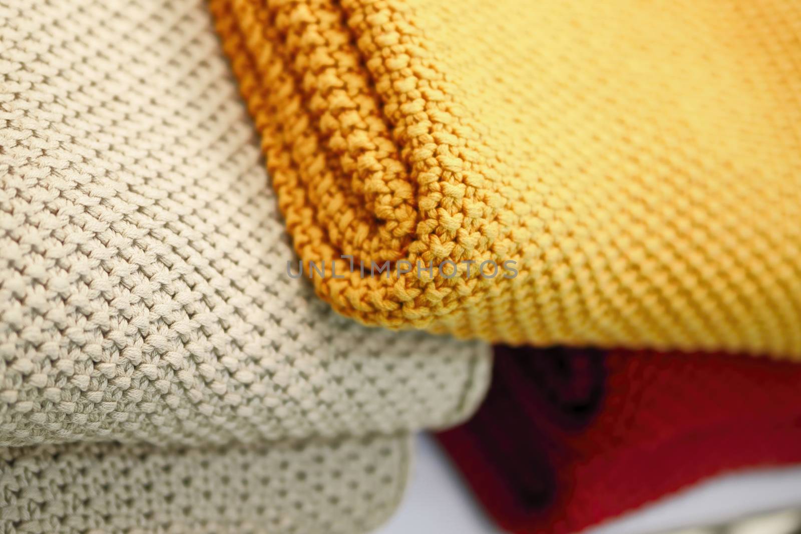 Red, beige and yellow knitted blankets. Cozy and warm in the winter season.