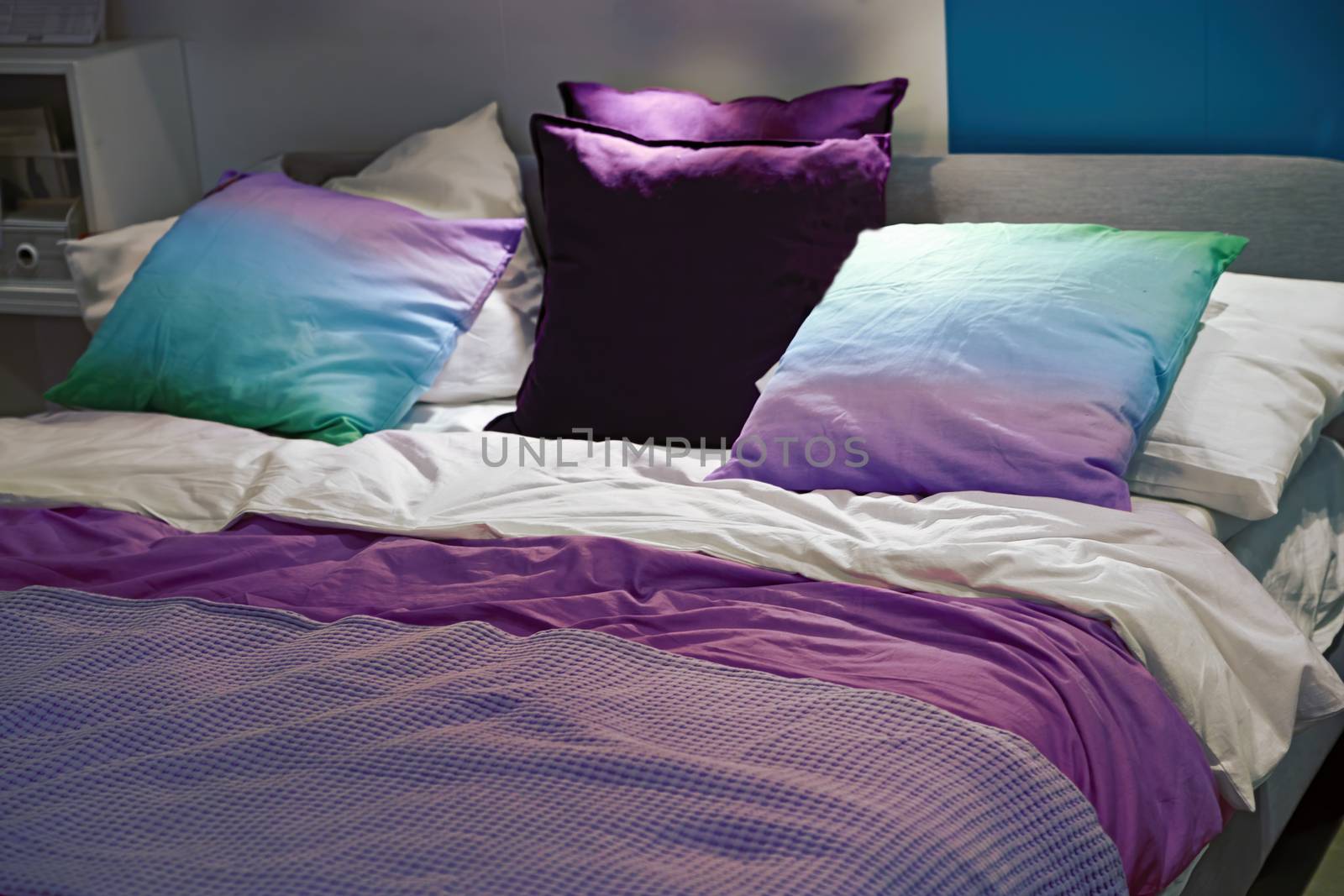 A cozy bed with soft pillows is shot close-up. Blurred background.