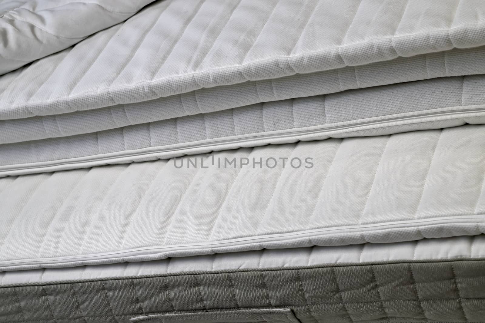 Folded white new bed mattresses filmed close-up