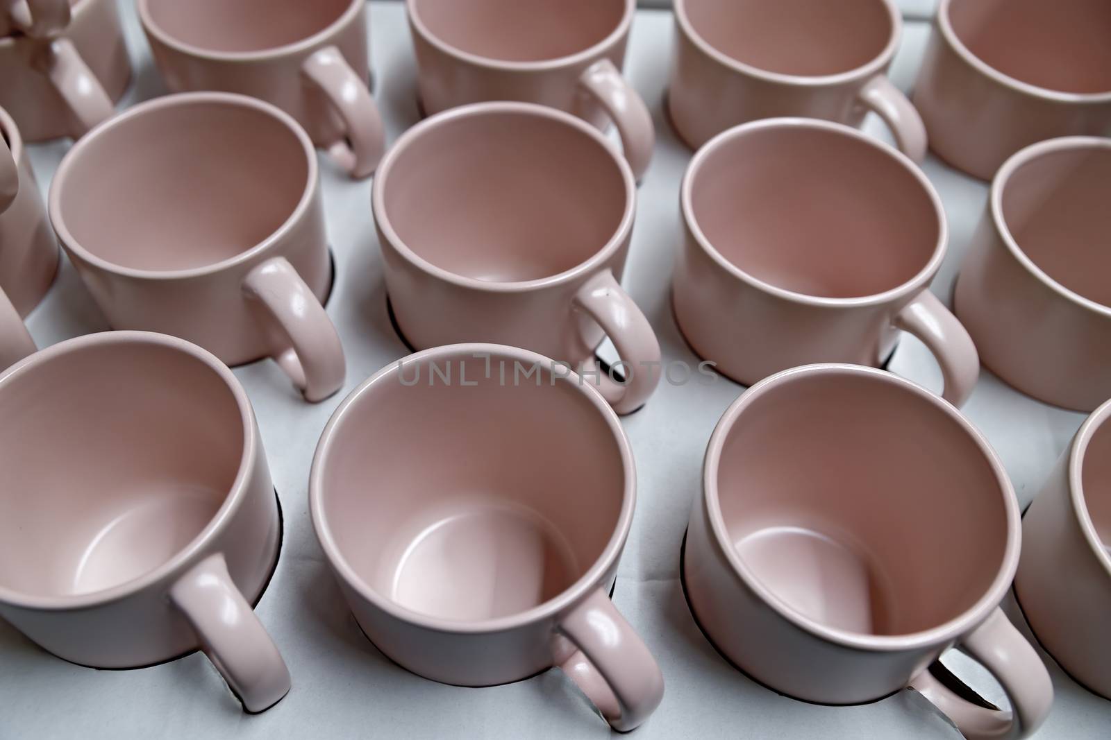 Rows of little pink tea mugs. Abstract background.
