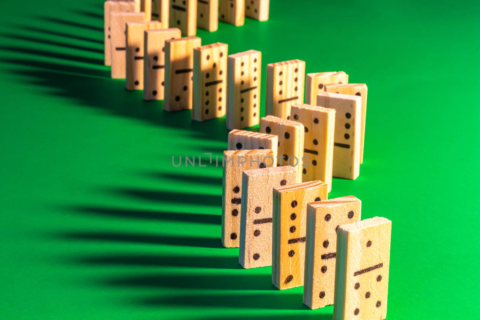 Wooden Dominoes with Long Shadows Standing Up by colintemple