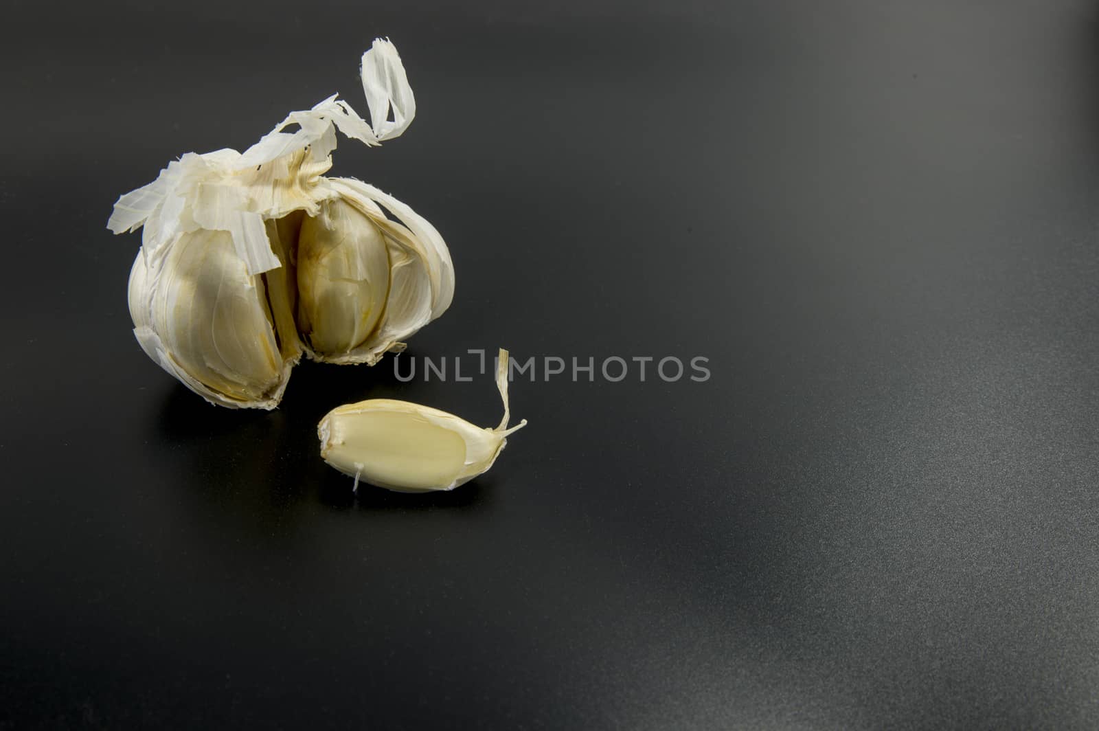 fresh garlic on black background as ingredient for food