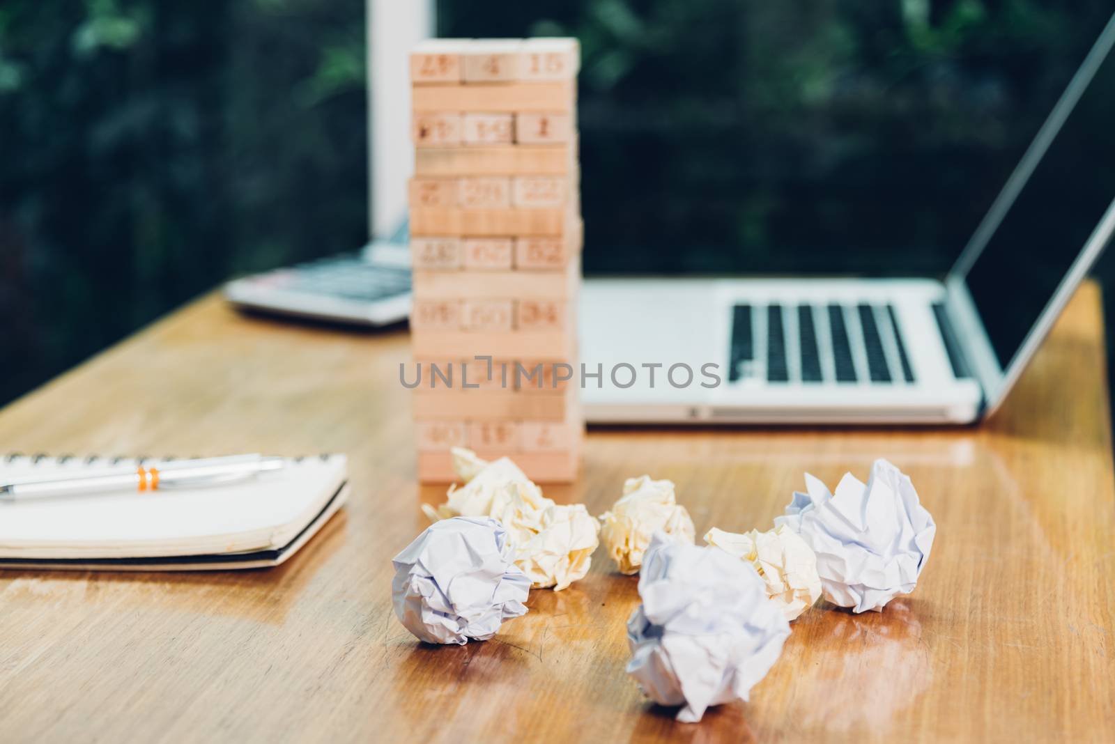 Business game wood block tower fail with paper crumpled on desk office