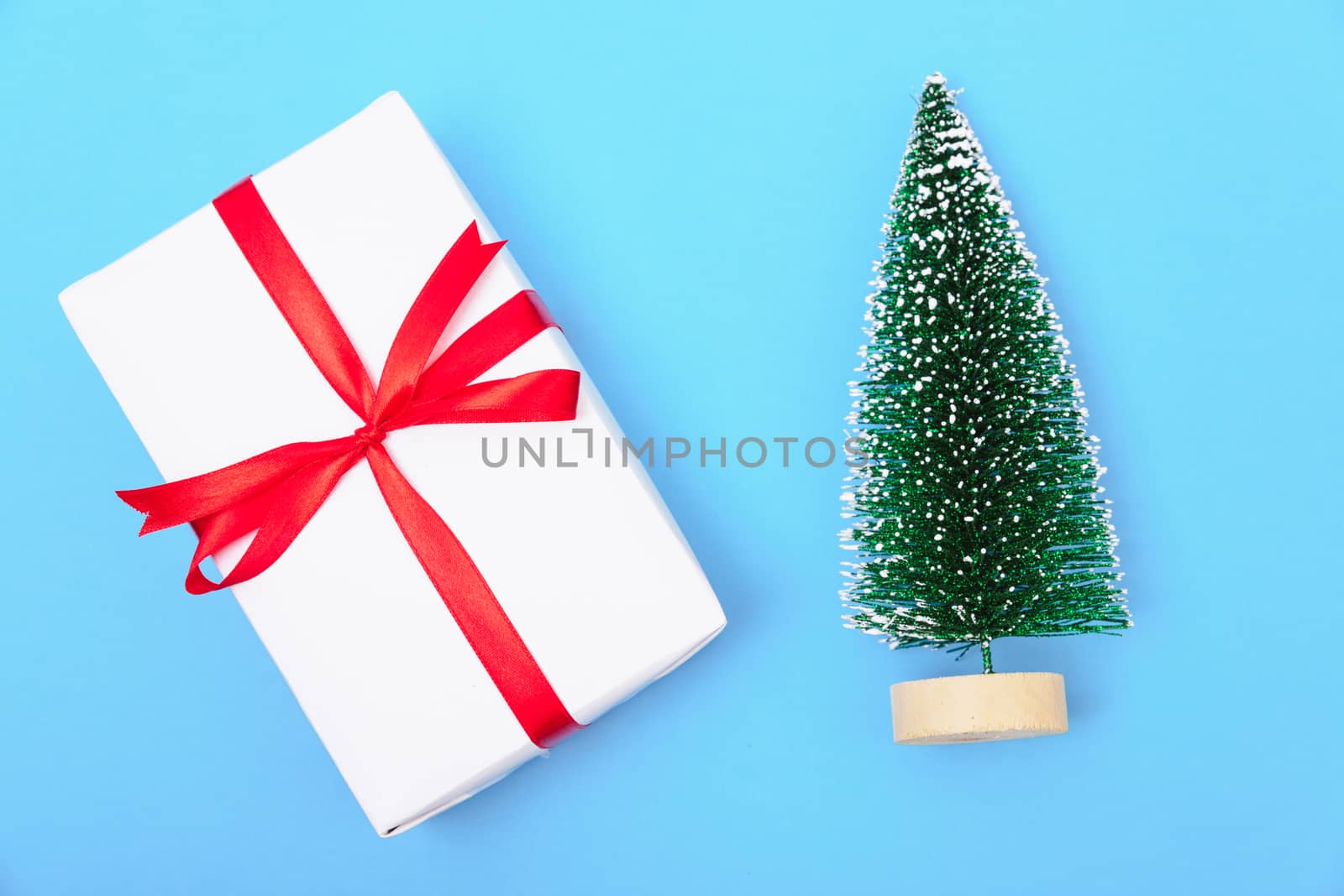 Happy New Year and Christmas 2020 or valentine day, top view craft paper wrapped present gift box craft and fir tree on blue background with copy space for your text