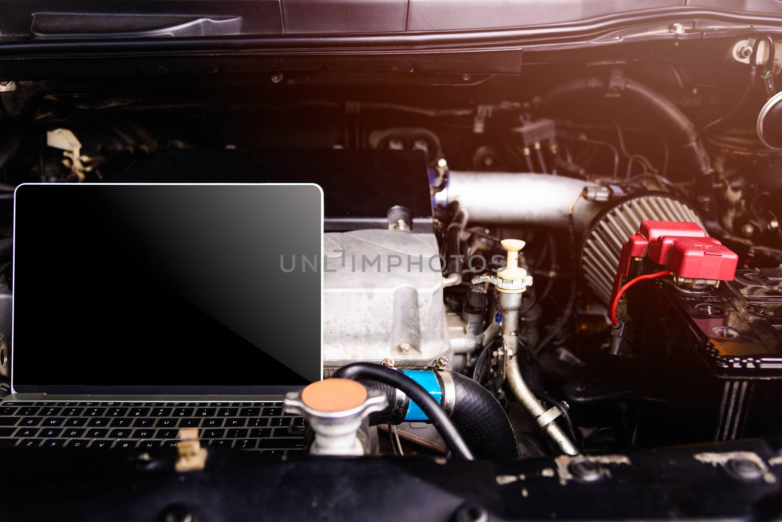 Laptop computer on car mechanic engine for service at workshop