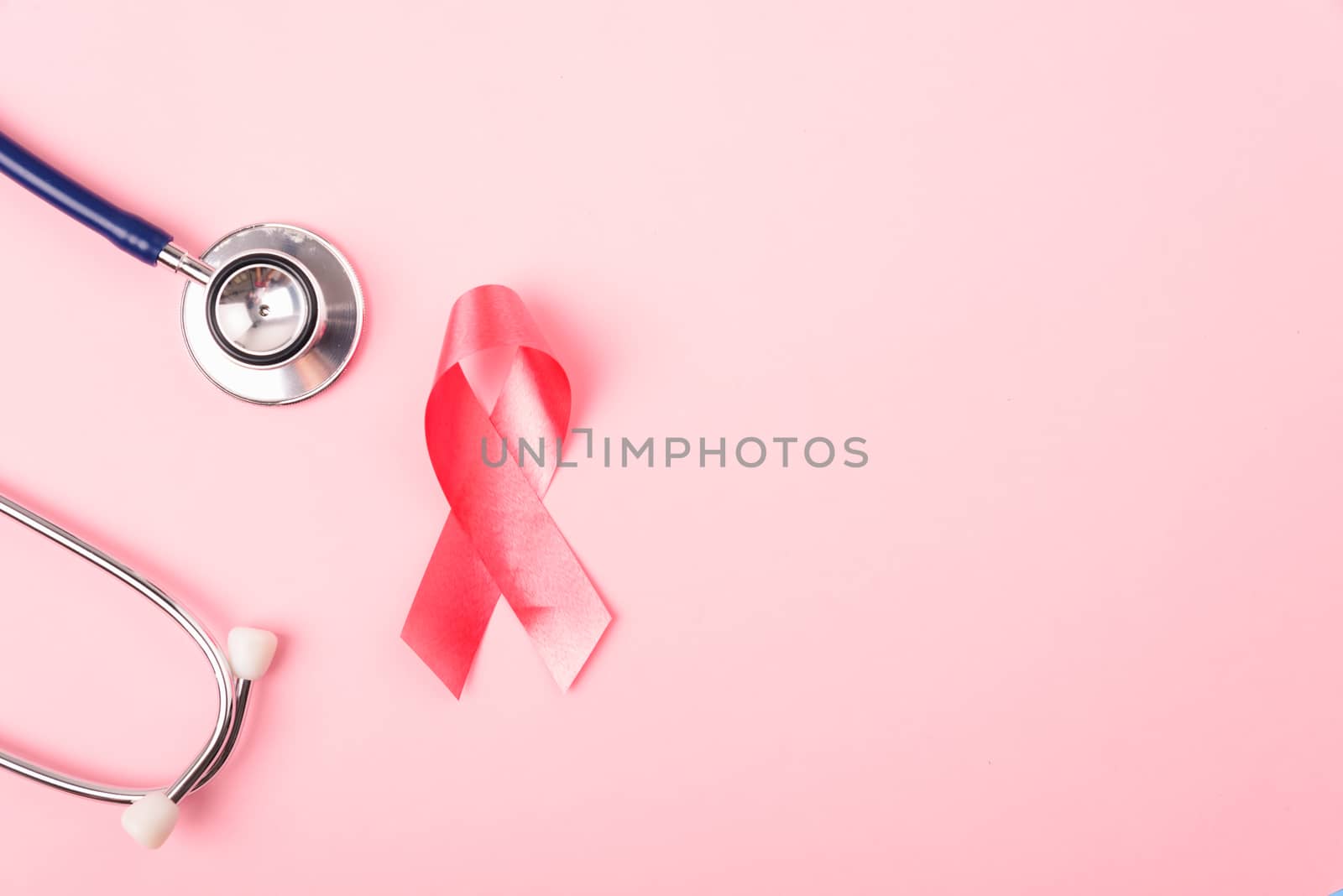 Breast Cancer Awareness Month Health concept, top view flat lay pink ribbon and stethoscope on pink background with copy space for your text