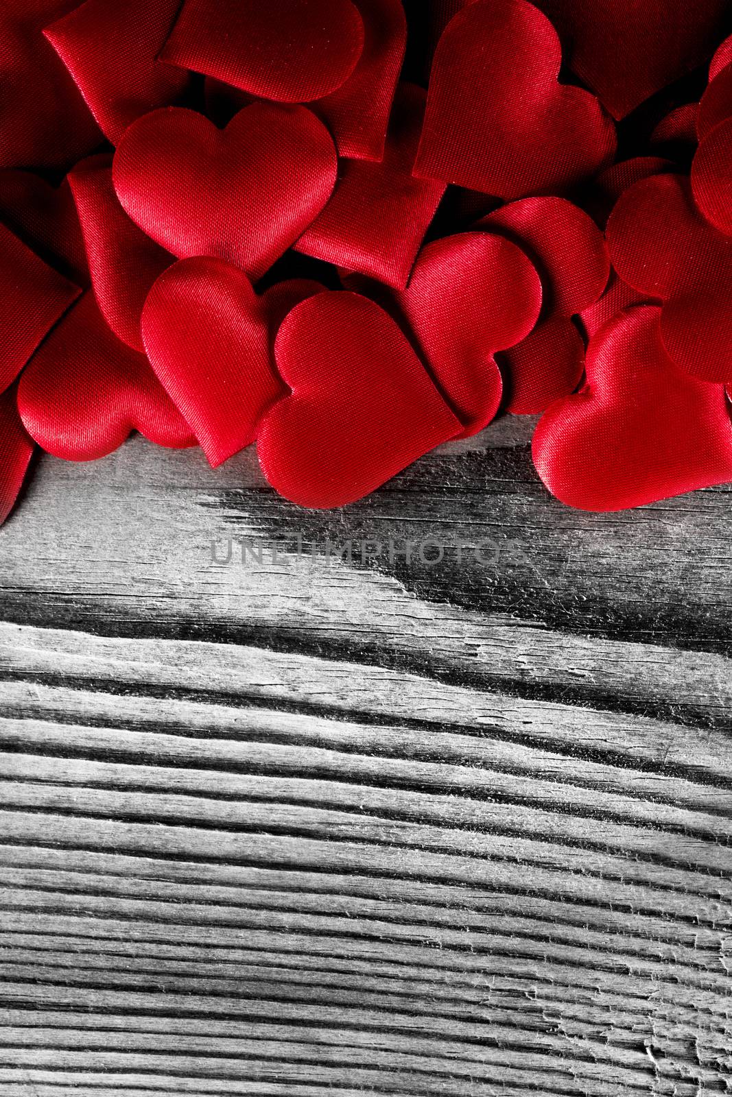 Valentine's day many red silk hearts on wooden background, love concept