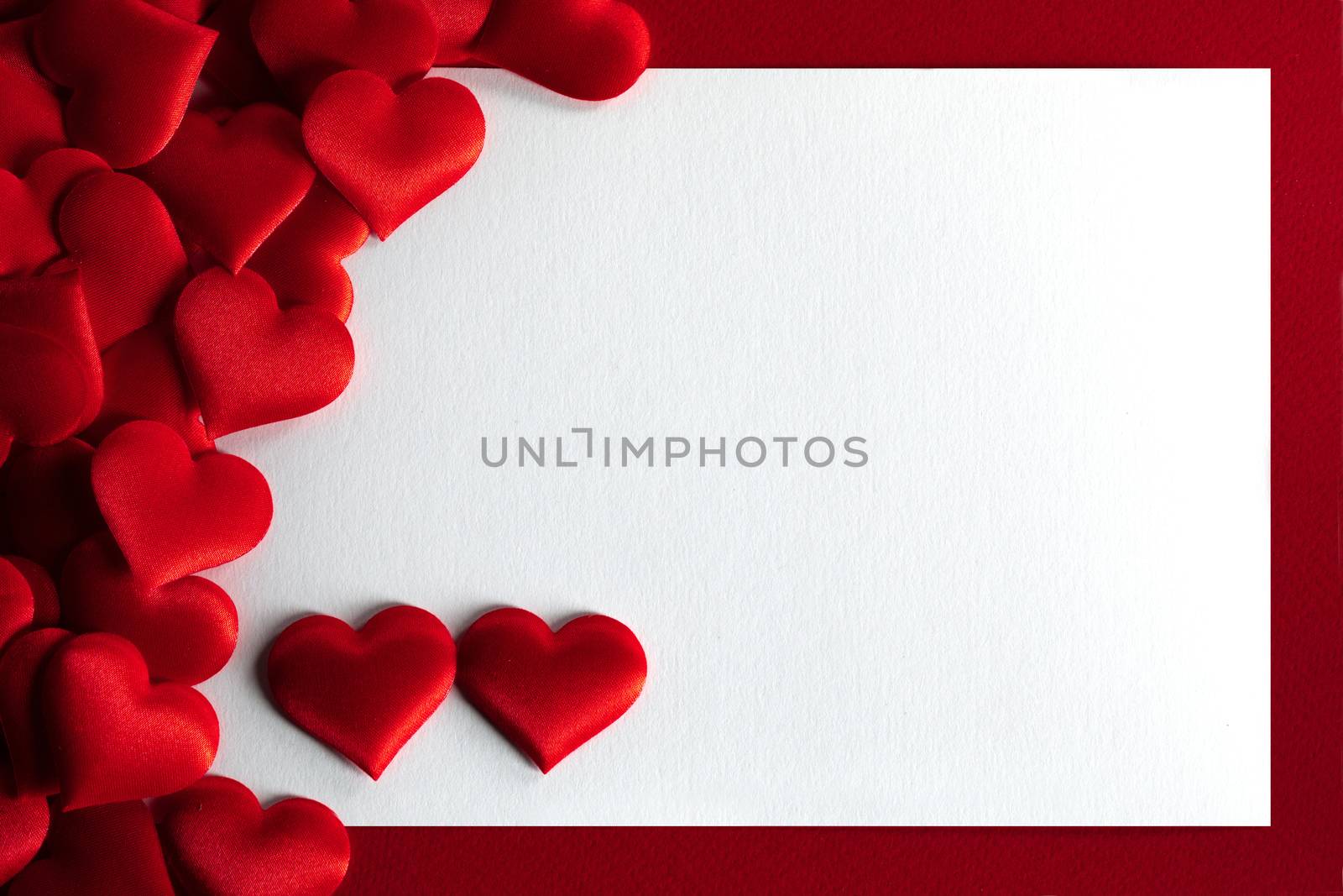Valentine's day many red silk hearts background , border frame with white card with copy space, love concept