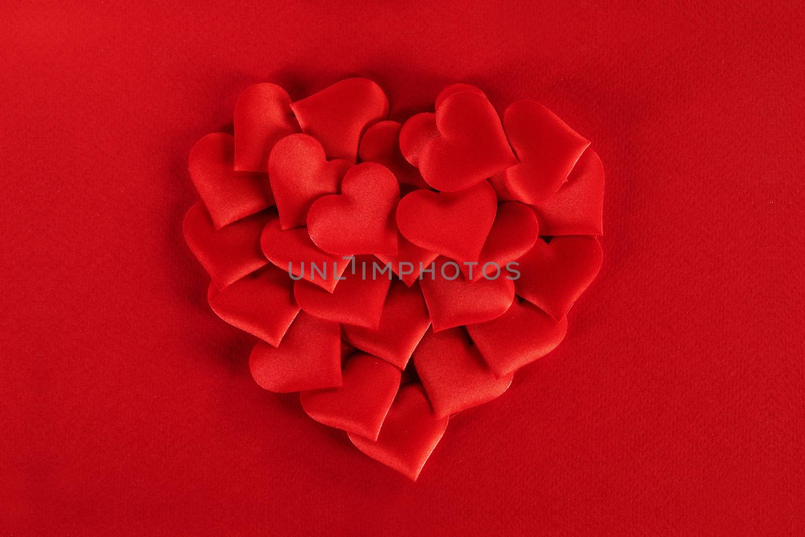 Valentine's day many red silk hearts ob paper background, love concept