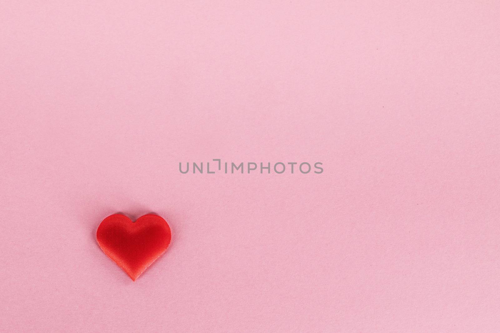 Valentine's day red silk heart on pink paper background, love concept
