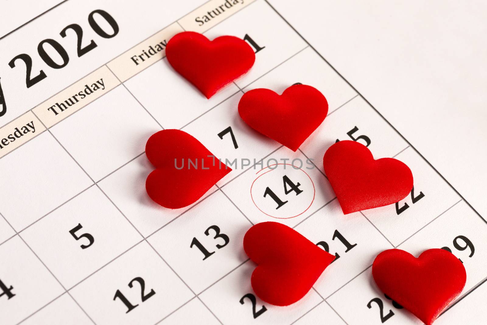 Valentine's day red silk hearts on calendar with 14 february date background, love, celebration concept