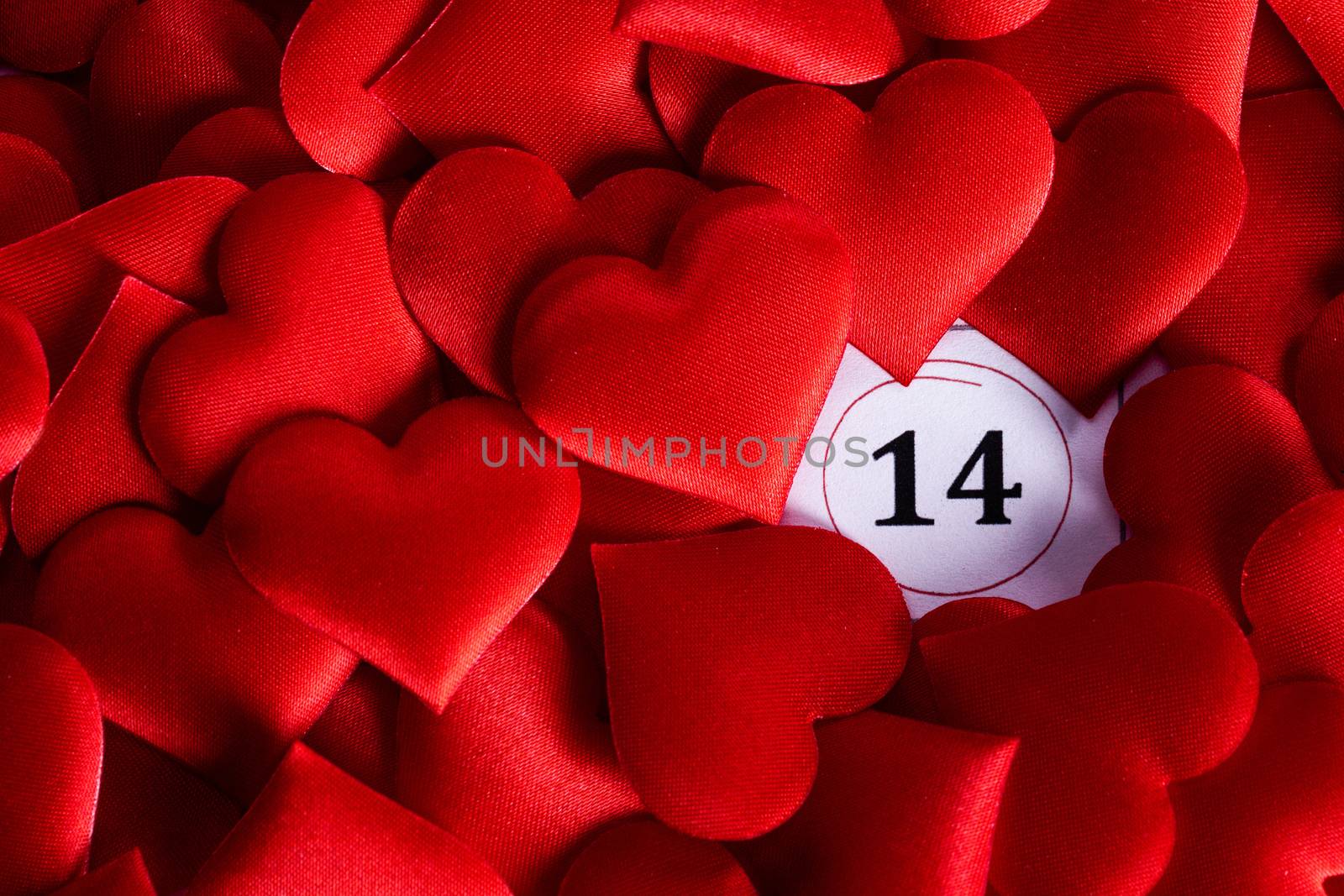 Valentine's day red silk hearts on calendar with 14 february date background, love, celebration concept