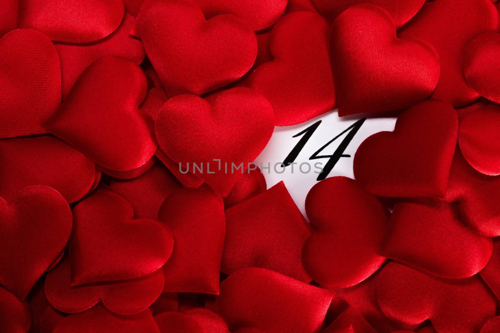Valentine's day red silk hearts on calendar with 14 february date background, love, celebration concept