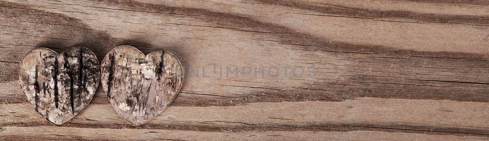 Two damaged rough rotten hearts on wooden background with copy space , love, Valentines day card