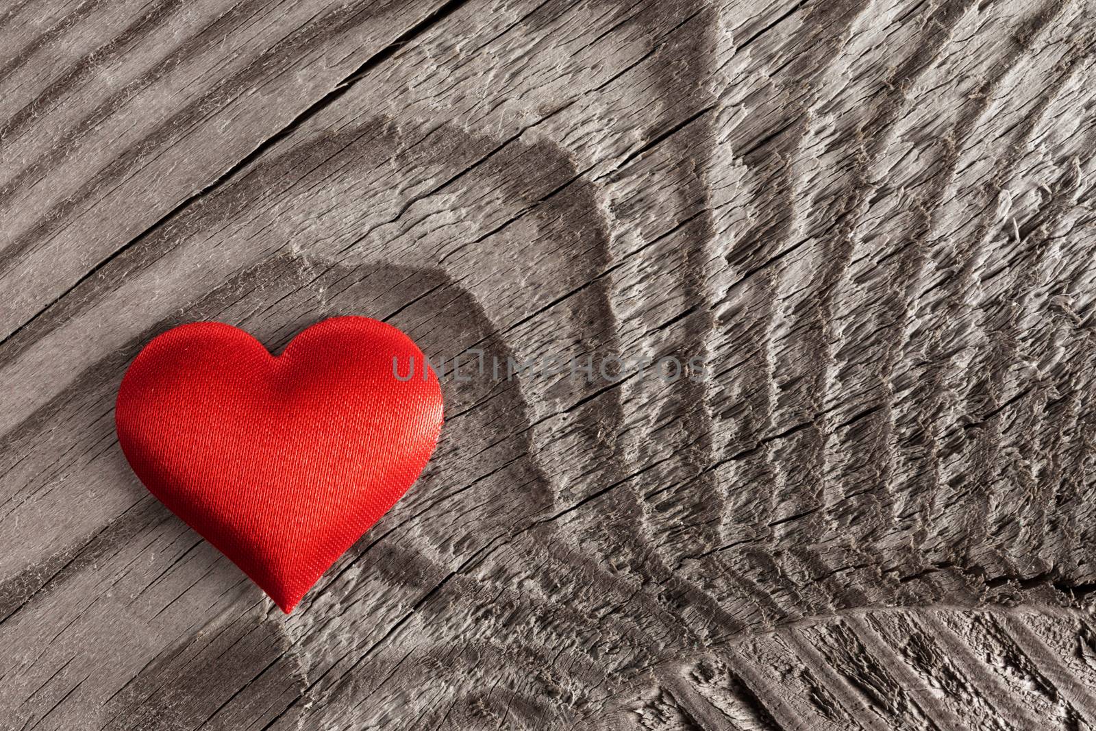 Valentine's day red silk heart on wooden background, love concept