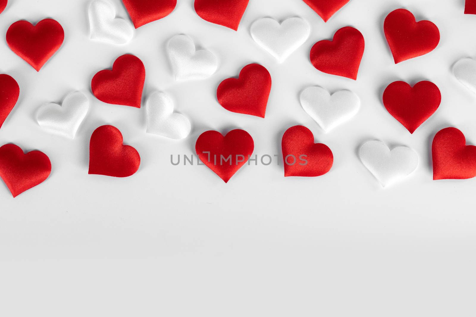 Valentine's day many red and white silk hearts on white background , border frame with copy space, love concept