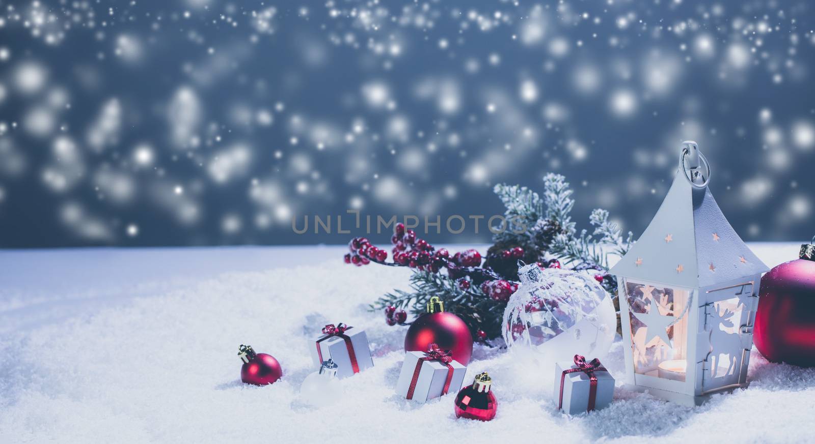Lantern and red and white christmas decoration on snow and magic lights background