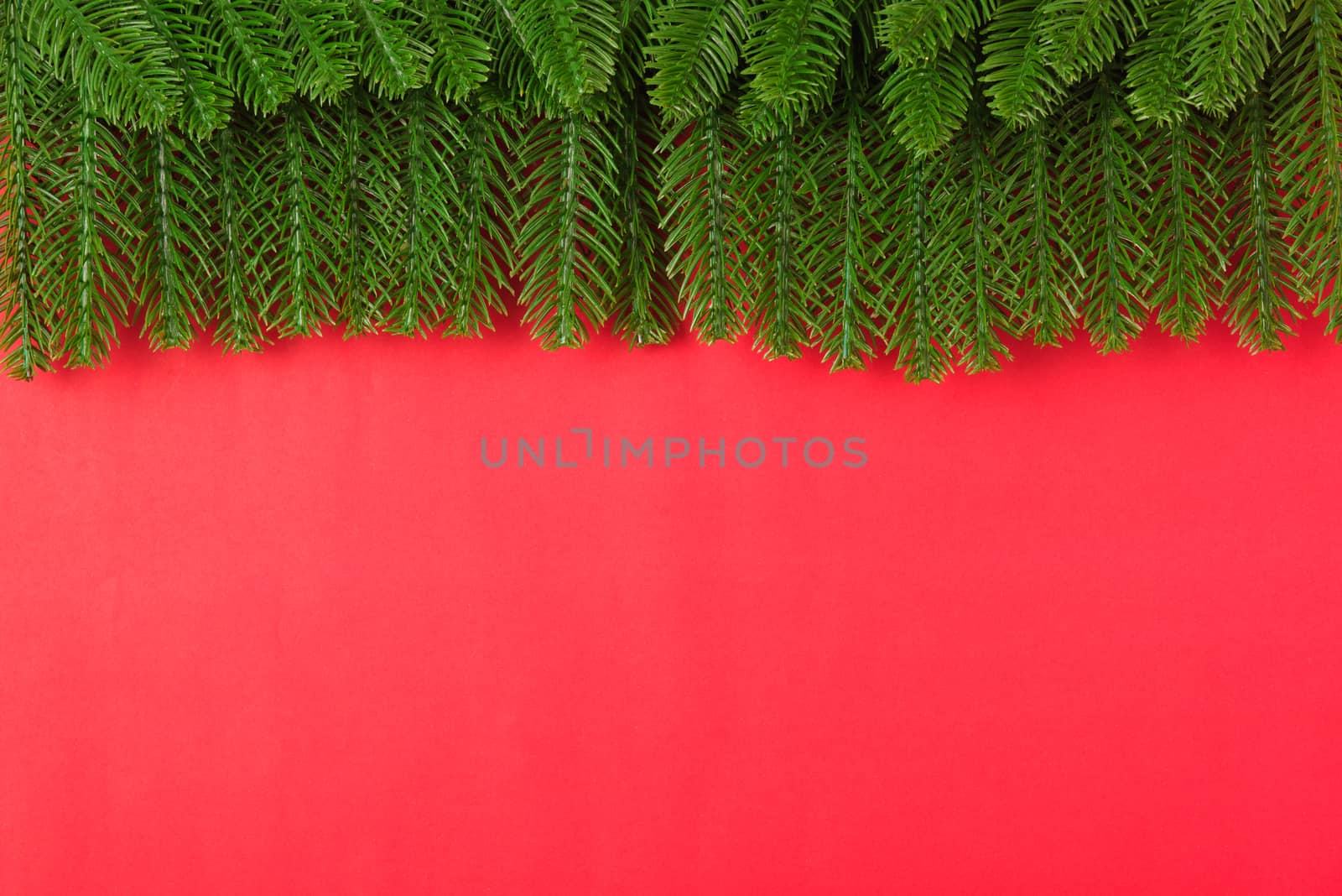 Happy new year or christmas day top view flat lay fir tree branches on red background with copy space for your text