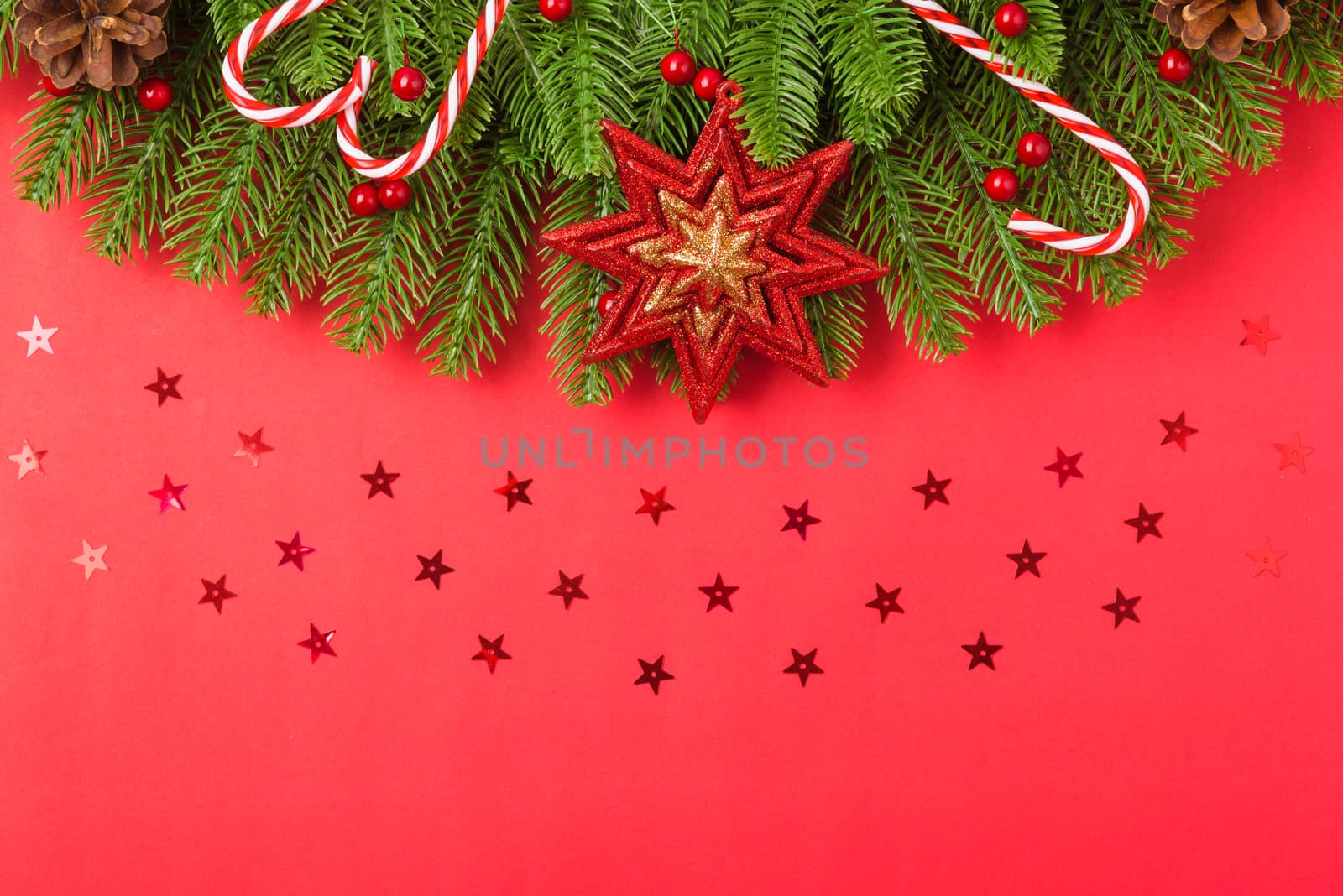 Happy new year or christmas day top view flat lay fir tree branches and ornaments decoration on red background with copy space for your text